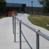 Grind To A Halt Round Handrail Minders installed on an outdoor handrail.
